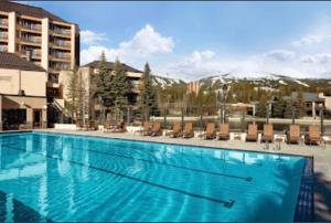 a large swimming pool with chairs and a building at NEW! Marriott Slope View Ski in Ski out Luxury Studio Sleeps 4 Full kitchen, Amenities & Fee Parking in Breckenridge
