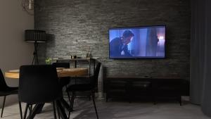 a flat screen tv hanging on a brick wall at Zofia Apartments in Lębork
