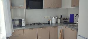 a kitchen with white cabinets and a counter top at Krūmu apartment in Liepāja