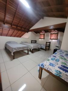 a room with two beds and two tables in it at Chalé no Caborê in Paraty