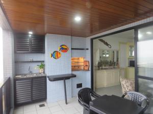 a kitchen with a table and a sink in a room at Ap Matinhos - Pé na areia e Vista para o Mar - Praia Brava - Caiobá in Matinhos