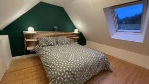 a bedroom with a bed and a green wall at Maison bretonne - cottage in Lézardrieux