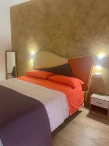 a bedroom with a large bed with orange pillows at B&B Airport 26 in Azzano San Paolo
