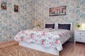 a bedroom with a bed with a floral bedspread at Guesthouse Suzdalskiy Hutor in Suzdal