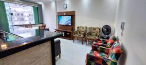 sala de estar amplia con TV y sillas en Universo Palace 604 - Vista mar com 2 Suítes, en Santos
