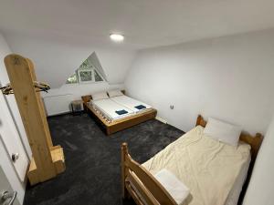 two beds in a small room with a window at Jére Lak in Băile Homorod