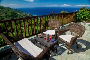 three chairs and a table on a balcony with the ocean at Lions Nine in Mouresi