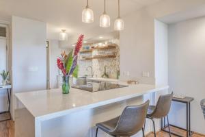 una cocina con una isla con sillas y una encimera en Kahana Villas E408, en Napili-Honokowai