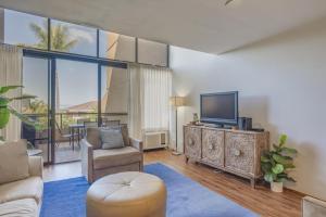 Una sala de estar con un televisor de pantalla plana y un sofá. en Kahana Villas E408, en Napili-Honokowai