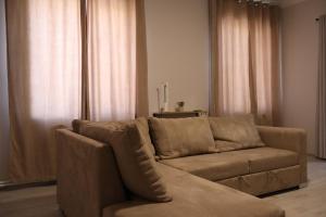a living room with a brown couch and curtains at Gyumri House Midtown in Gyumri