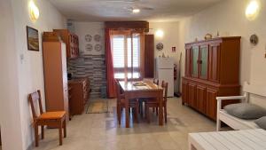 a kitchen with a table and chairs and a refrigerator at Villa Palma Di Mare in Portopalo