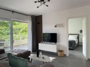 a living room with a couch and a tv and a bed at Apartments No26 in Povile
