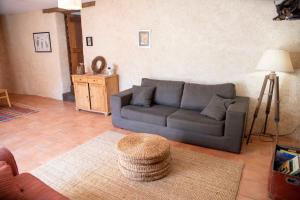 een woonkamer met een bank en een tafel bij La Hulotte in Saint-Malon-sur-Mel