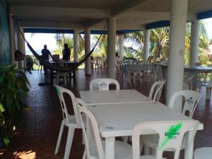 a white table and white chairs and a hammock at Hostal in Sontecomapan