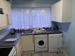 a kitchen with a washing machine and a sink at Glasgow St George's Room in Glasgow