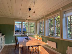 une salle à manger avec une table en bois et des fenêtres dans l'établissement Charming Countryside Cottage, à Varekil