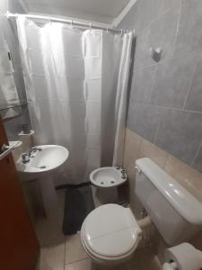 ein Badezimmer mit einer weißen Toilette und einem Waschbecken in der Unterkunft Gotas de Rocio N1 in San Antonio Oeste