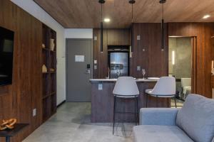 een woonkamer met een bank en een keuken bij Edifício New Time Apto 1406-Mandi Hospitalidade in Maceió