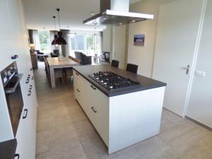 a kitchen with a stove and a dining room at Villa Mer - Large luxury family holiday home Villa Nausikaä in Cadzand