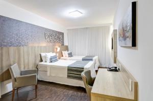 Cama ou camas em um quarto em Allia Gran Pampulha Suites