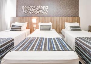 Cama ou camas em um quarto em Allia Gran Pampulha Suites