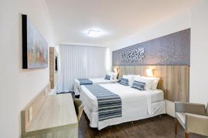 Cama ou camas em um quarto em Allia Gran Pampulha Suites