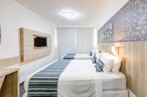 Cama ou camas em um quarto em Allia Gran Pampulha Suites