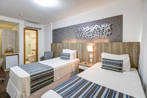 Cama ou camas em um quarto em Allia Gran Pampulha Suites