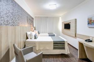 Cama ou camas em um quarto em Allia Gran Pampulha Suites