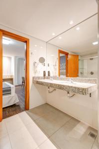 Cama ou camas em um quarto em Allia Gran Pampulha Suites
