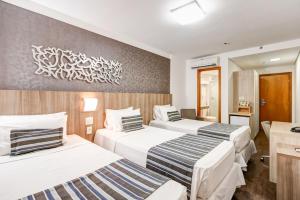 Cama ou camas em um quarto em Allia Gran Pampulha Suites