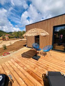 2 sillas y una sombrilla en una terraza de madera en L etoile au cœur de la nature, en Rosselange