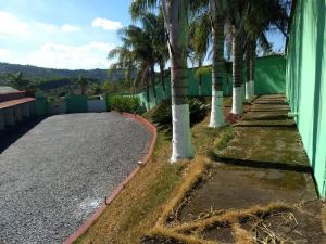 a road with palm trees next to a building at Hotel e Motel Rarus in Igaratinga