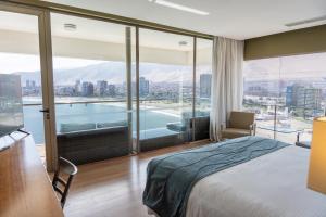 a hotel room with a large bed and a large window at Terrado Suites Iquique in Iquique +41 photos