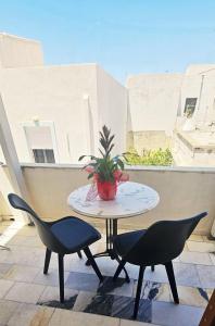 a table with two chairs and a potted plant on a balcony at Hotel Rea in Naxos Chora