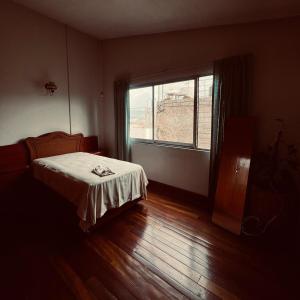 a bedroom with a bed and a large window at Casa Carmesí in Oaxaca City