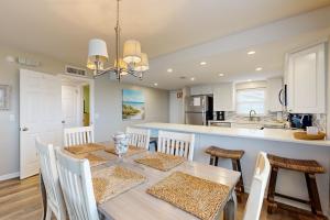 Oceanfront corner condo with sunrise-view balcony, pool & 1-minute walk to beach في فرناندينا بيتش: مطبخ وغرفة طعام مع طاولة وكراسي