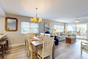 Oceanfront corner condo with sunrise-view balcony, pool & 1-minute walk to beach في فرناندينا بيتش: غرفة طعام وغرفة معيشة مع طاولة وكراسي +12 صورة