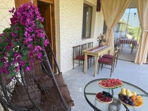 a balcony with a table with fruit and flowers at JIV Guesthouse in Odzun in Odzun