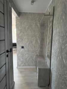 a hallway with a staircase with a marble wall at 1-комнатная квартира в центре города in Kostanay