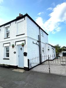a white house with a gate and a fence at Autumn Cottage in Filey