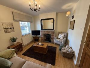 a living room with a couch and a fireplace at Autumn Cottage in Filey