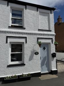 a white house with two windows and a door at Autumn Cottage in Filey