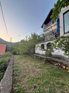 a house with a yard next to a building at Boracko jezero vikendica Ka&No in Konjic