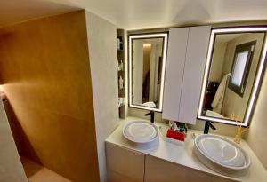zwei Waschbecken im Bad mit zwei Spiegeln in der Unterkunft Private Rooftop Jacuzzi in La Celle-sous-Gouzon + 11 Fotos