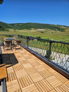 a wooden deck with a table and chairs on a balcony at Luxury Villa Mašić in Čardaci