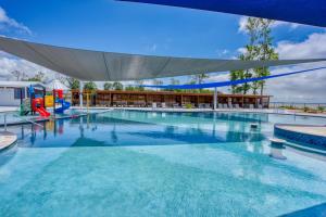 a large swimming pool with a playground and an umbrella at Lagoon Ranch RV Resort in Onalaska