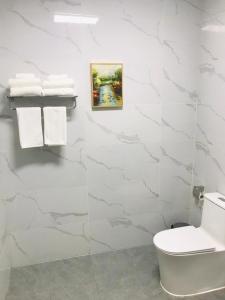 a white bathroom with a toilet and towels at Nausori Plaza Hotel in Vunimono +53 photos