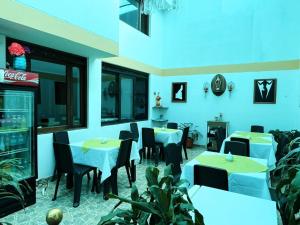 a restaurant with tables and chairs and blue walls at VILLA LEWANA 2 in Villa de Leyva