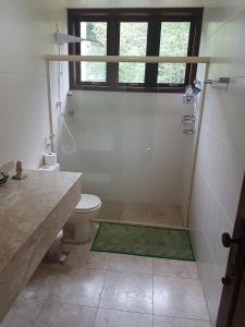 a bathroom with a shower with a toilet and a window at Paraíso aconchegante em Itaipava in Itaipava